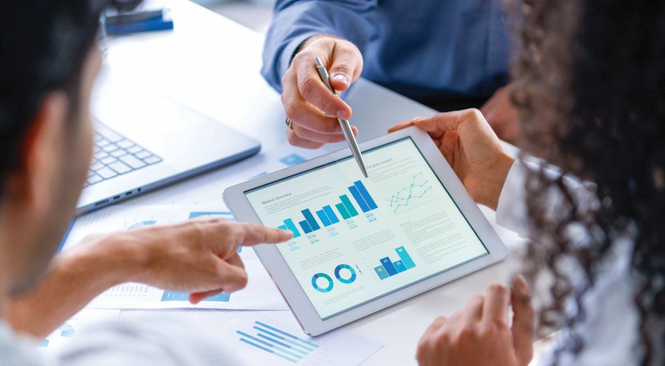people on tablet with graphs and charts