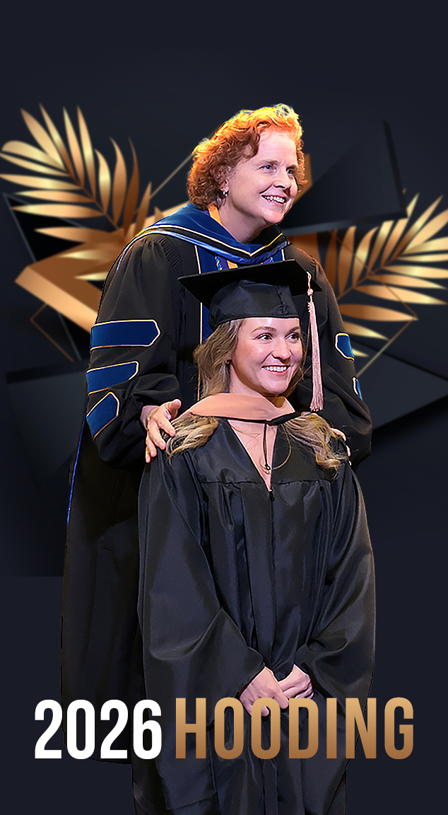 Faculty member putting hood on Master's degree recipient announcing Hooding ceremony